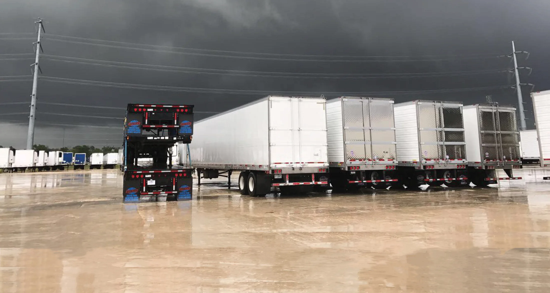Commercial trailers on the Utility Trailer of Texas lot beneath a dramatic Texas sky